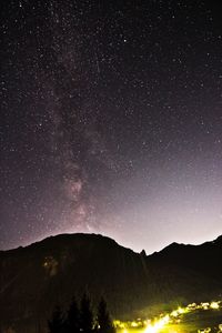 Scenic view of silhouette mountains against star field at night