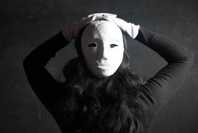 Rear view of woman wearing mask against wall