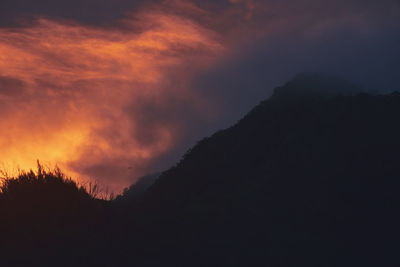 Scenic view of silhouette mountains against sky at sunset