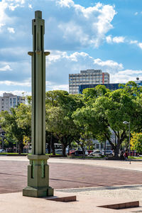 Trees by street against sky in city