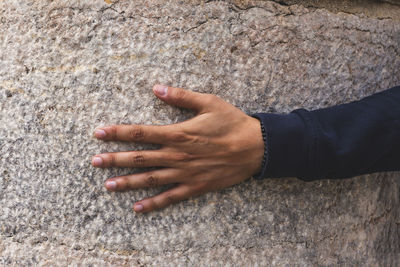 Midsection of man touching rock