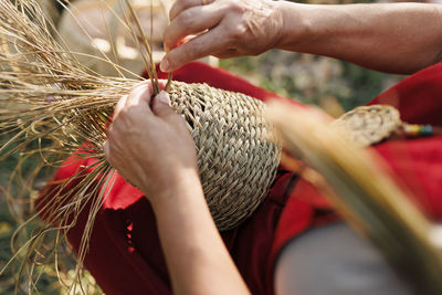 Hands of artisan making basket with esparto grass