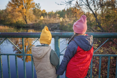 Rear view of men standing by railing