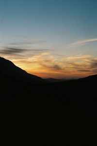Scenic view of silhouette mountains against sky at sunset