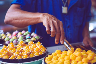 Midsection of man preparing food at market stall