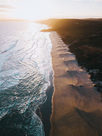 Aerial view of beach against sky during sunset
