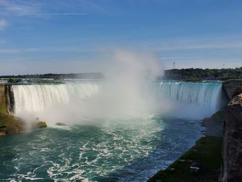 Scenic view of waterfall against sky
