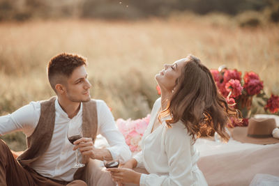 Young couple sitting on mobile phone outdoors