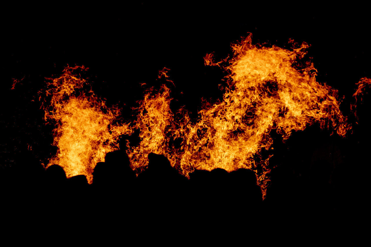 LOW ANGLE VIEW OF FIRE CRACKERS AGAINST BLACK BACKGROUND