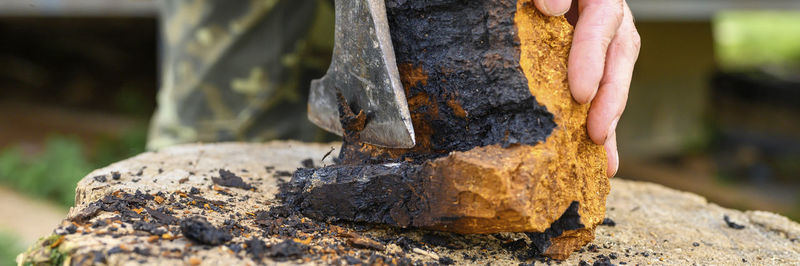 Close-up of person working on rock