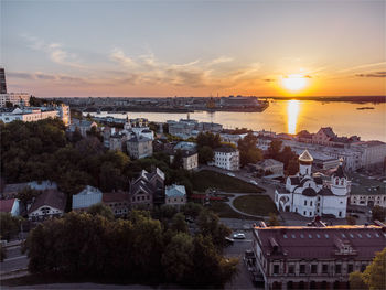 High angle view of buildings and sea against sky during sunset