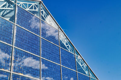 Low angle view of modern building against blue sky