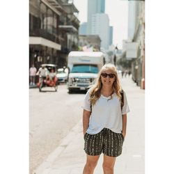 Young woman standing on sidewalk in city