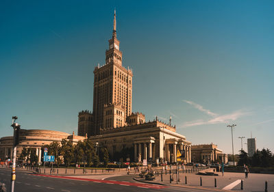 View of city buildings against blue sky