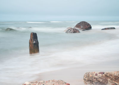 Rocks on beach against sky