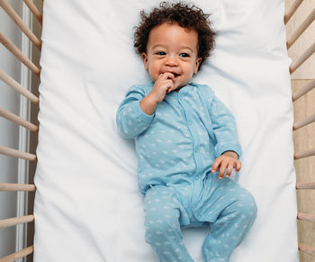 Portrait of cute baby lying on bed