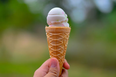Close-up of hand holding ice cream cone