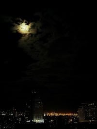 Low angle view of illuminated cityscape against sky at night