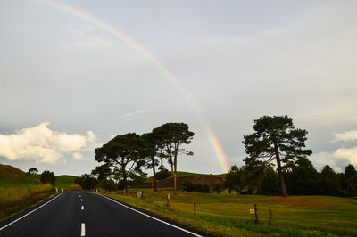 Scenic view of rainbow over road against sky