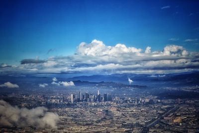 Aerial view of cityscape against blue sky