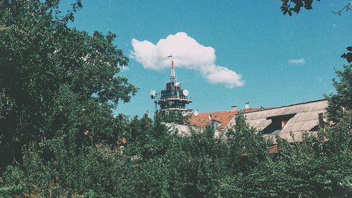 Low angle view of clock tower amidst buildings against sky