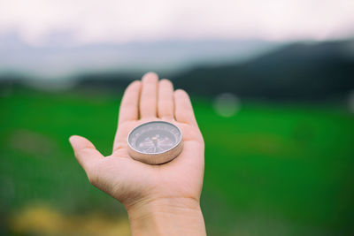 Cropped image of hand holding navigational compass