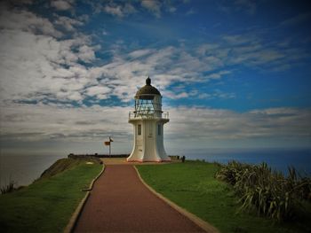 Lighthouse by sea against sky