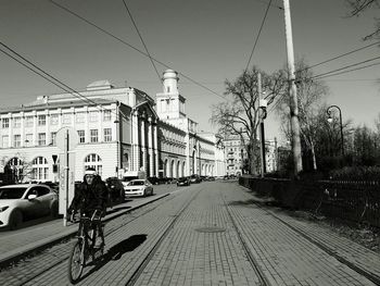 Cars on street in city against clear sky