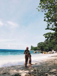 Woman with mother standing at beach