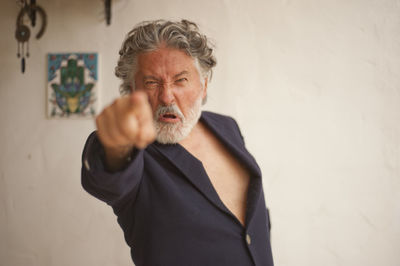 Portrait of man standing against wall