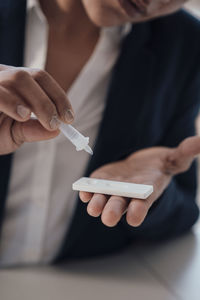 Businesswoman taking pregnancy test at office