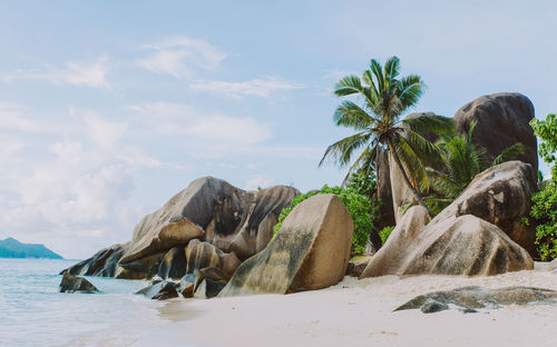 Scenic view of rocks by sea against sky