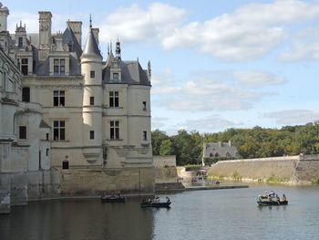 Boats in river against buildings in city