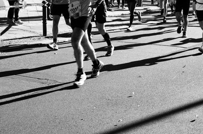 Low section of men running on street in marathon