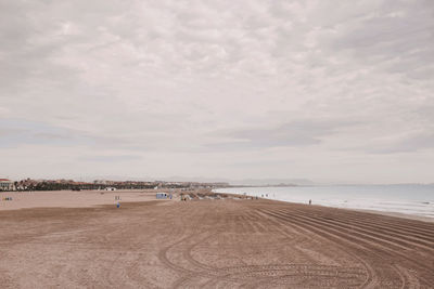 Scenic view of beach against cloudy sky