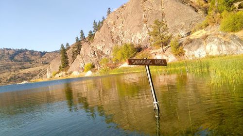 Scenic view of lake by mountain against sky