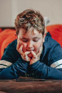 Portrait of boy sitting on table at home