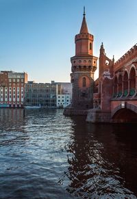 Bridge over river against buildings in city