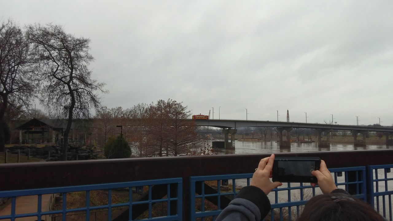 lifestyles, leisure activity, men, sky, building exterior, architecture, built structure, personal perspective, railing, tree, person, sitting, city, low section, day, relaxation