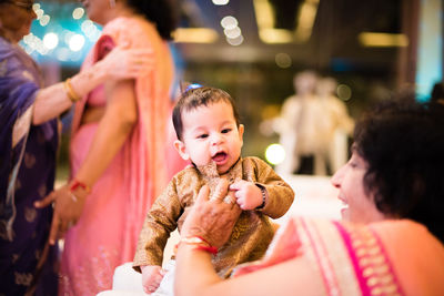 Grandmother playing with son by people