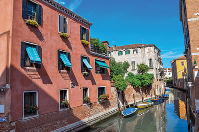 Canal overview with boats and buildings in the city center of venice, italy.