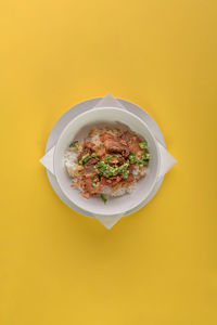 High angle view of salad in bowl against yellow background