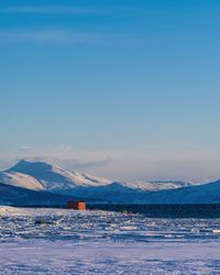 Scenic view of snowcapped mountains against blue sky during sunset