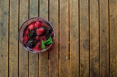 Directly above shot of bowl with raspberry on wooden table