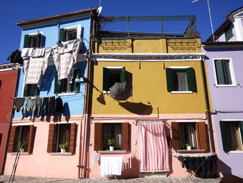 Low angle view of clothes hanging on building against sky