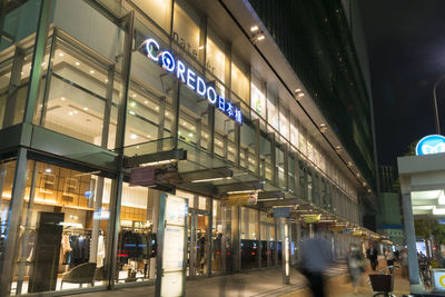 Blurred motion of people walking on illuminated city at night