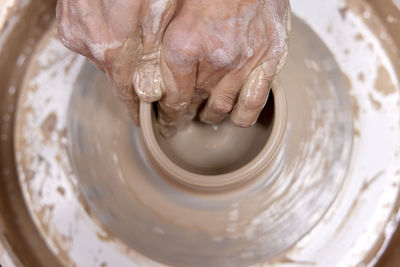 Cropped hand making pottery