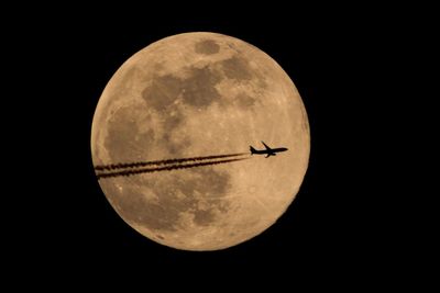 Low angle view of airplane against sky at night