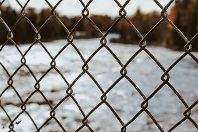 Close-up of chainlink fence against sky