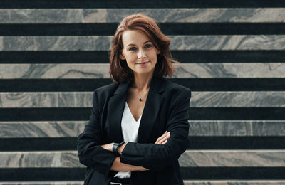 Young woman standing against corrugated iron